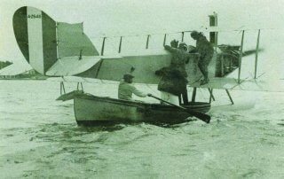 The Governor, General Sir James Willcocks is helped on board the Curtis Jenny seaplane in Hamilton Harbour.